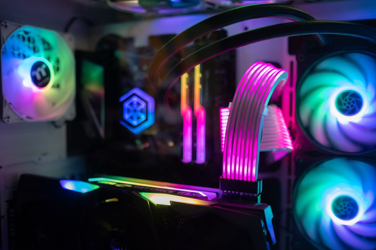 services-04 Close-up of glowing RGB components inside a custom gaming PC tower featuring cooling fans and vivid lights.